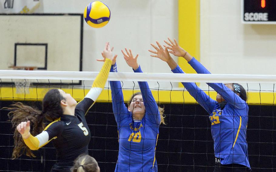 American School In Japan's Brianne Roberts hits at the net against Yokota's Lucy Wellons and Trinity Stegall.