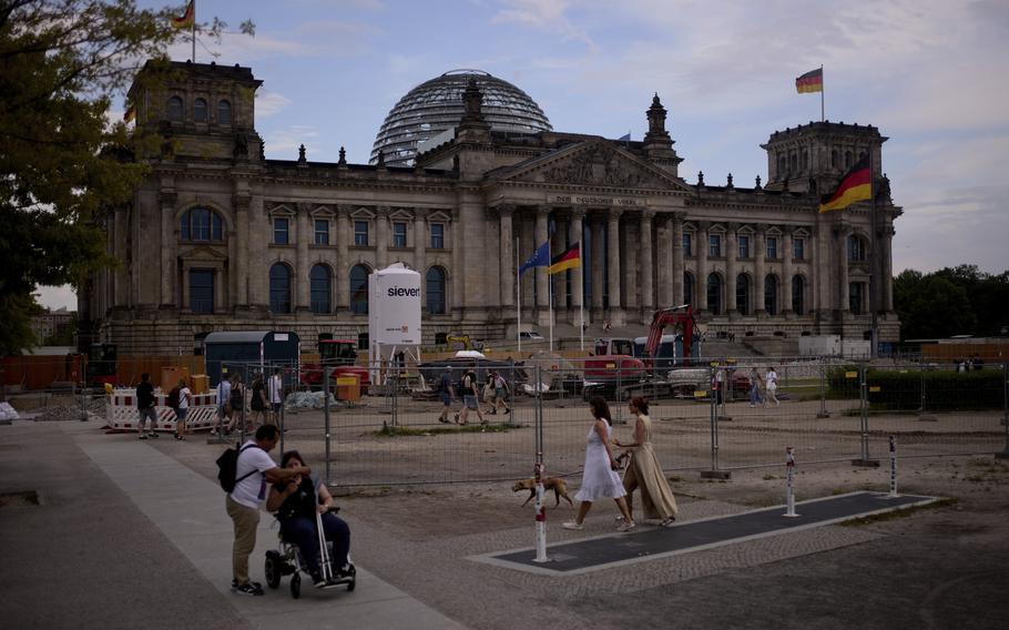 People walk in front of the Reichtag Building in Berlin.