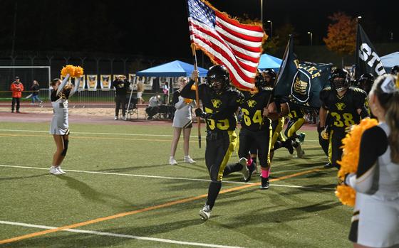 Stuttgart Senior Dan Myrick carries the flag and leads the Panthers on to the field for the DODEA Europe Division I championship game against the Vilseck Flacons on Oct. 28, 2023, at Stuttgart Highschool. This is the third consecutive time the two teams have met in the championship game. 