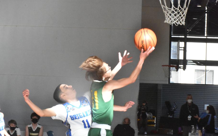 Alconbury's Alfonso Sanchez drives for a basket on a sun-speckled court while defended by Brussels' Isaiah Rivera on Wednesday, Feb. 23, 2022, at the DODEA-Europe Division III basketball tournament.