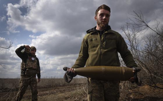 Ukrainian soldiers carry shells to fire at Russian positions on the front line, near the city of Bakhmut, in Ukraine's Donetsk region, on March 25, 2024. Approval by the U.S. House of a $61 billion package for Ukraine puts the country a step closer to getting an infusion of new firepower. But the clock is ticking. Russia is using all its might to achieve its most significant gains since the invasion by a May 9 deadline.