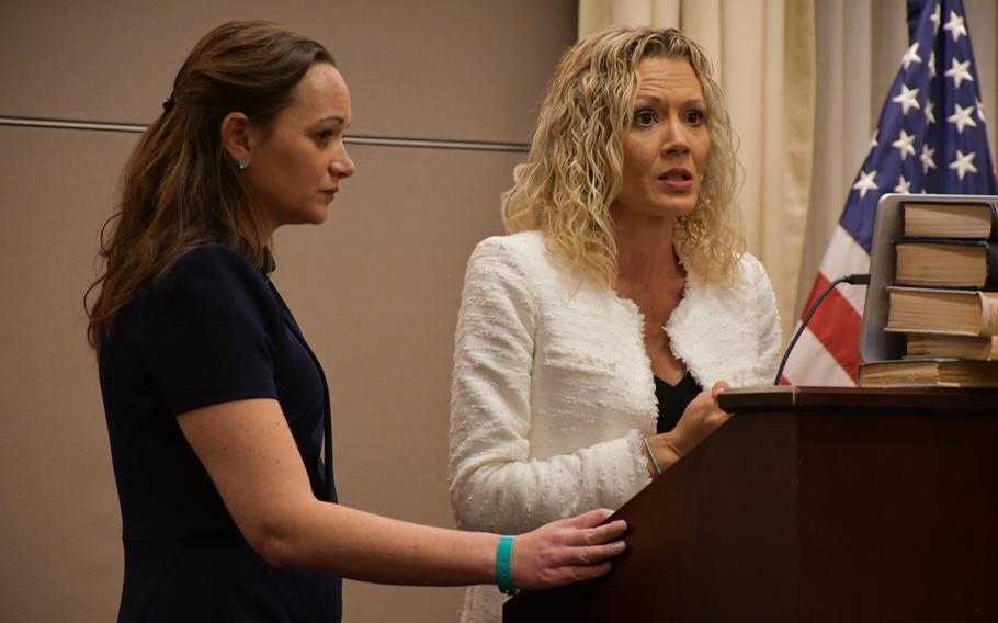 Jamie Simic, right, a Navy spouse who was made ill by contaminated water at Joint Base Pearl Harbor-Hickam, Hawaii, speaks Tuesday, Feb. 8, 2022, on Capitol Hill in Washington.  Kristina Baehr, left, Simic's lawyer, stands by.  Simic urged Congress to relieve himself, other service members and families exposed to the contaminated water. 