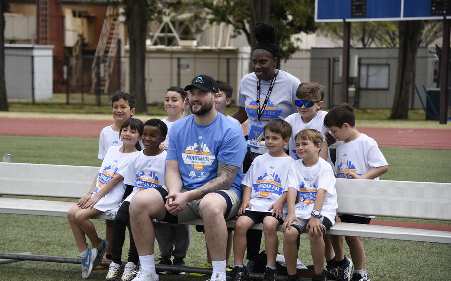 Atlanta Falcons defensive end Morgan Fox poses with young athletes.