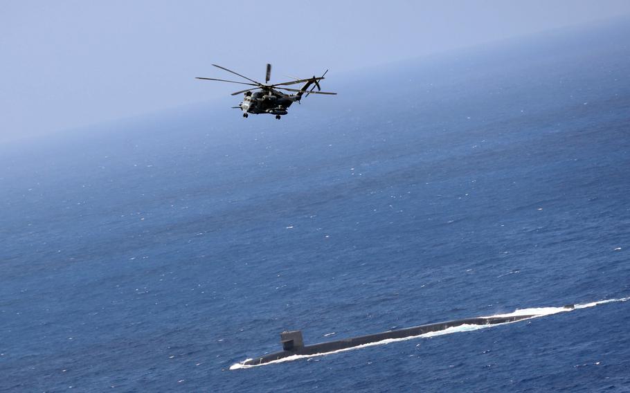 A Marine Corps CH-53E Super Stallion prepares to drop supplies to the Ohio-class ballistic missile submarine USS Maine in the Philippine Sea, May 9, 2023. 