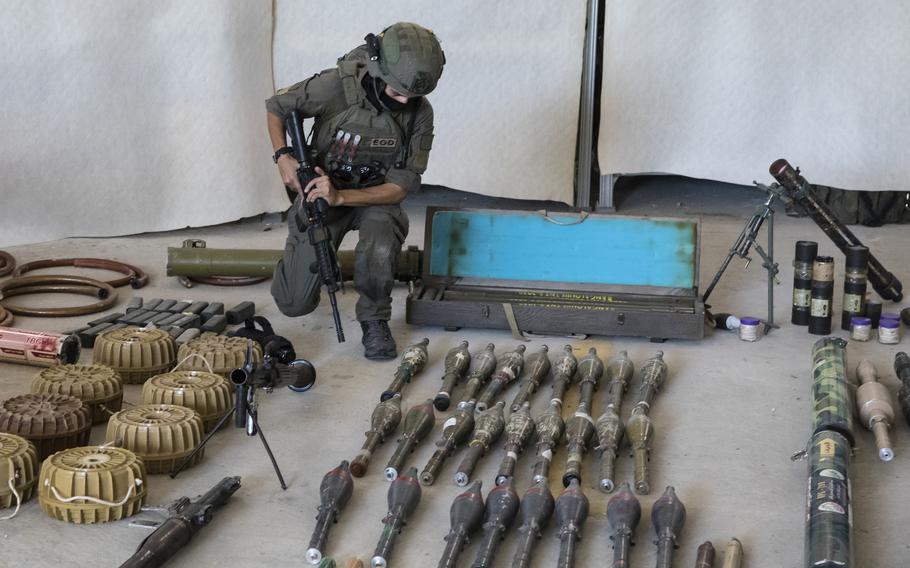An Israeli soldier displays military equipment and ammunition that Hamas and Palestinian militants used at the time of the attack on the Israeli south border with the Gaza Strip, on Oct. 20, 2023, in Haifa, Israel. 