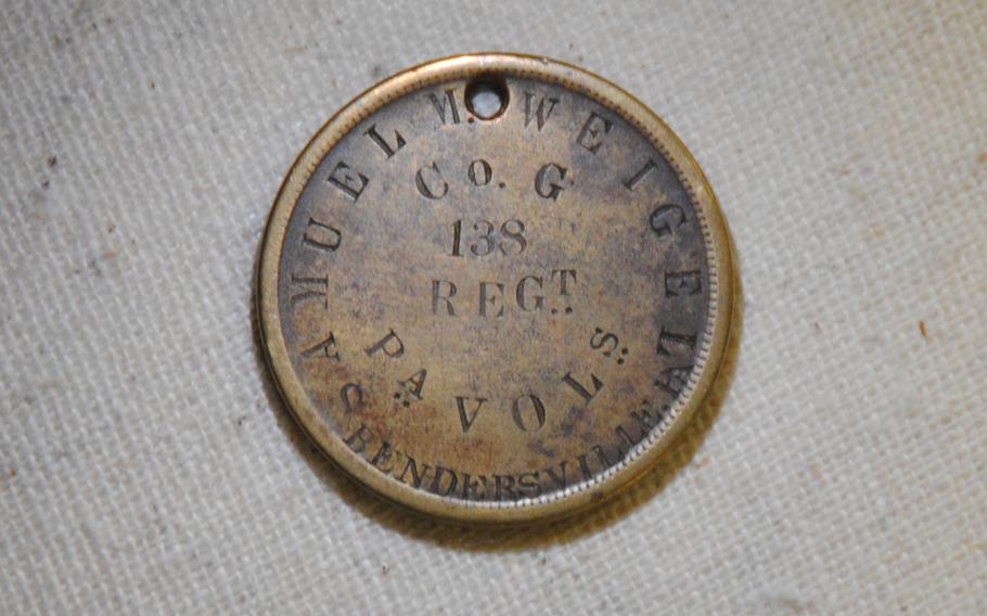 The back of a small, bronze-colored identification disk belonging to Samuel M. Weigel, a private with Company G of the 138th Pennsylvania Infantry. According to regimental history, Weigel was severely wounded during the Battle of Monocacy but survived. 