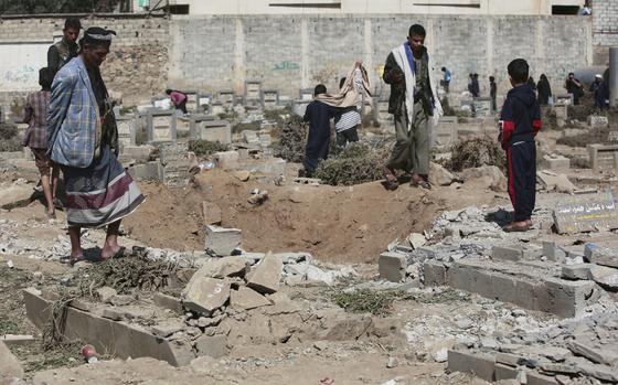 Yemenis look at a hole in the ground a day after it was struck by U.S. airstrikes.