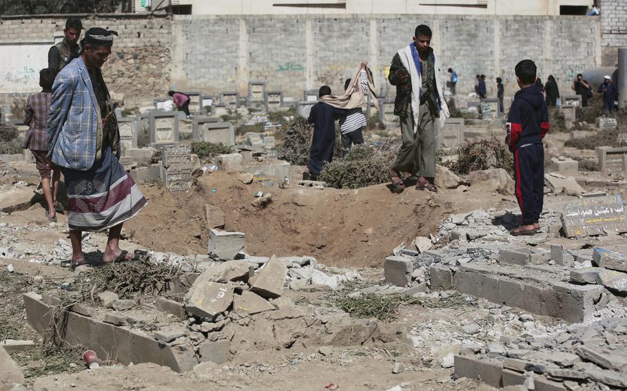 Yemenis look at a hole in the ground a day after it was struck by U.S. airstrikes.