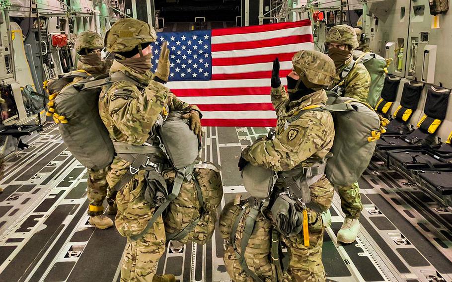 Maj. Travis Young, left, administers the oath of enlistment to Staff Sgt. Jesus Gloria, 4th Infantry Brigade Combat Team, 25th Infantry Division, during a ceremony Jan. 27, 2021, onboard an Air Force C-17 before a nighttime airborne operation at Joint Base Elmendorf-Richardson, Alaska. The Army is reducing soldiers’ reenlistment window from 15 months before the end of the contract to 12 months.