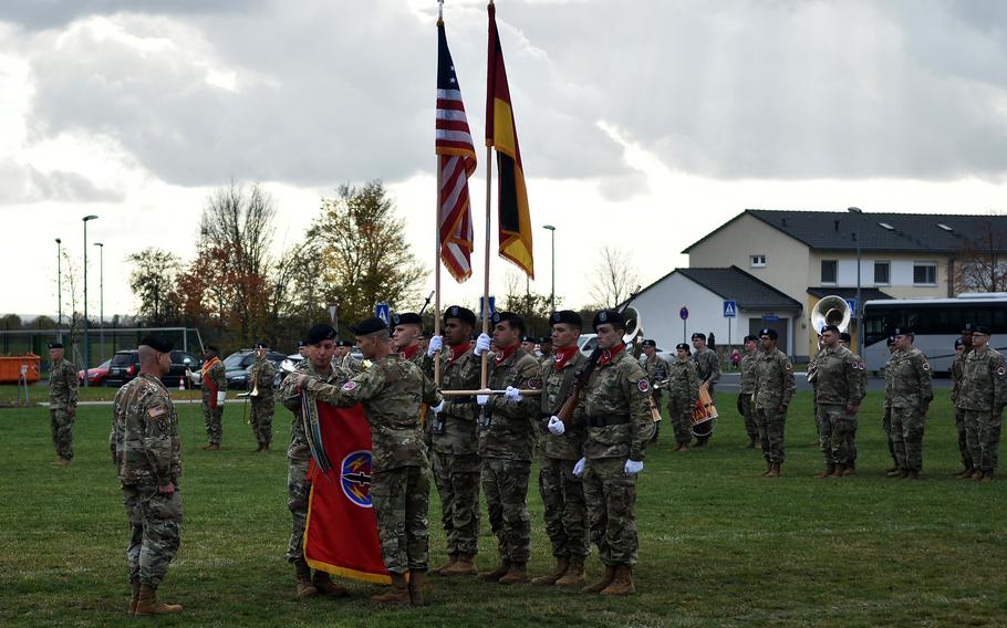 Maj. Gen. Stephen Maranian and Command Sgt. Maj. Darrell Walls of the 56th Artillery Command unfurl the unit's flag, while Gen. Christopher Cavoli, commander of U.S. Army Europe and Africa, looks on during the unit's reactivation ceremony, Nov. 8, 2021, in Wiesbaden, Germany. 