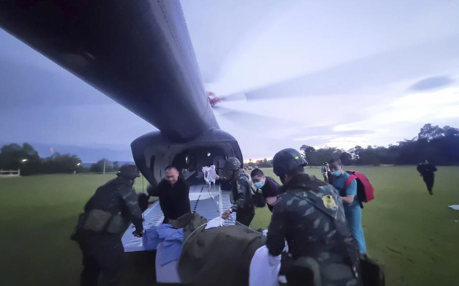 A person being carried into a helicopter.