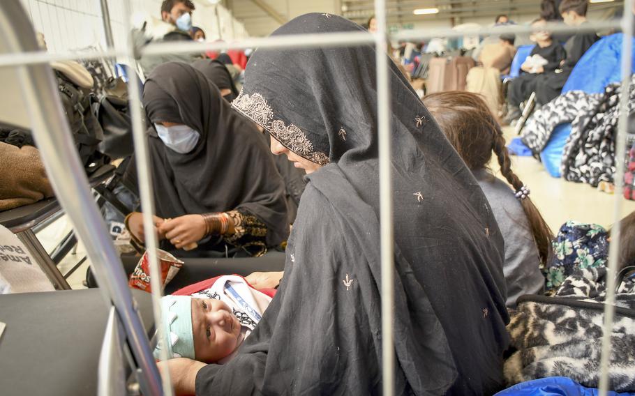 An evacuee from Afghanistan, Worahmina, holds her 15-day-old son Mustafa while waiting for a flight to the U.S. in a hangar at Ramstein Air Base in Germany on Wednesday, Sept. 1, 2021.