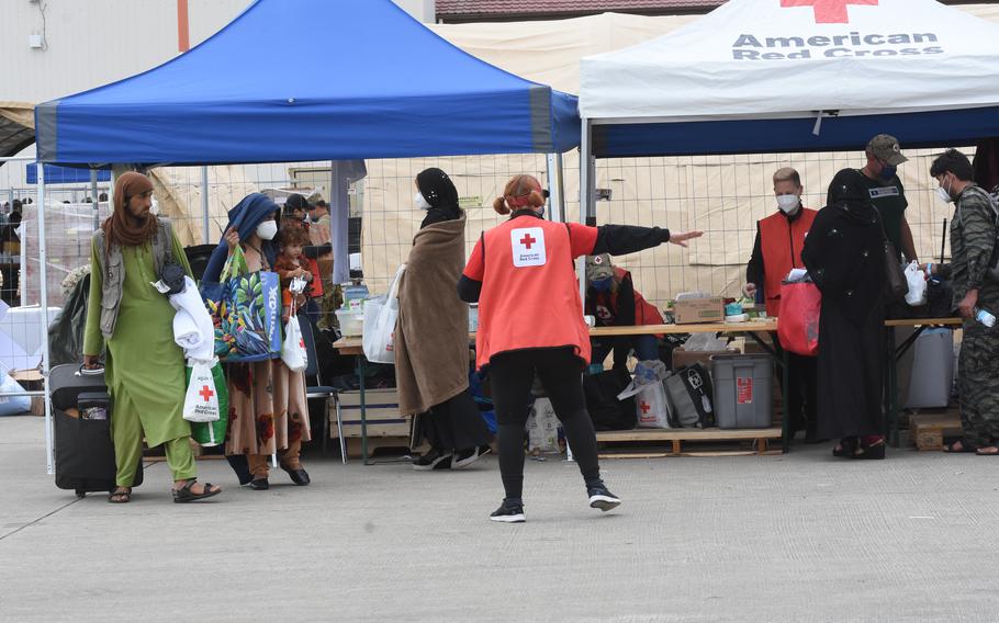 Volunteers with the American Red Cross hand out care packages and assist new arrivals from Afghanistan, Aug. 26, 2021. Ramstein was expecting about 10,000 more evacuees overnight Thursday. Some evacuees were to be housed temporarily at Rhine Ordnance Barracks, a neighboring Army base.