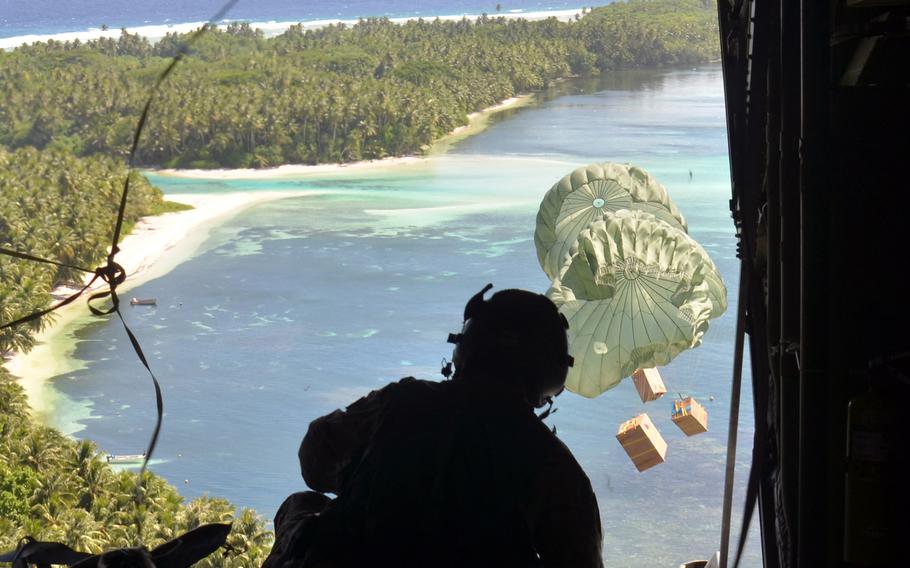 Staff Sgt. William Jenkins, a loadmaster with the 36th Expeditionary Airlift Squadron at Yokota Air Base, Japan, watches an Operation Christmas Drop bundles fall to Falalop, an island in the Federated States of Micronesia, Tuesday, Dec. 5, 2023. 