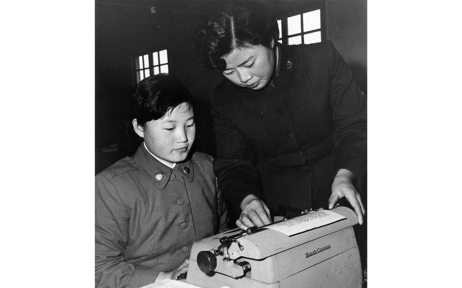 A Republic of Korea Women's Army Corps recruit gets instructions on how to work a typewriter during a typing class at the WAC Training Center in Seoul. 