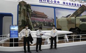 Workers wearing masks stand near missiles produced by China Aerospace Science and Industry Corp.displayed during the 13th China International Aviation and Aerospace Exhibition, also known as Airshow China 2021 on Tuesday, Sept. 28, 2021 in Zhuhai in southern China's Guangdong province. China on Friday, Jan. 21, 2022 criticized Washington for imposing sanctions on Chinese companies the U.S. says exported missile technology and accused the United States of hypocrisy for selling nuclear-capable cruise missiles. (AP Photo/Ng Han Guan)