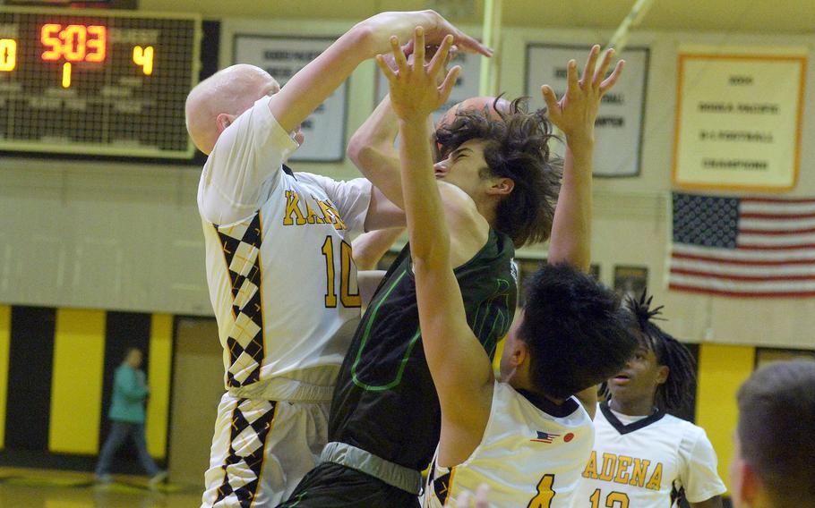 Kubasaki's Troy Harris crashes into Kadena defender Drew Eaglin during Friday's Okinawa boys basketball game. The Panthers won 49-44, completing a four-game season-series sweep of the Dragons.