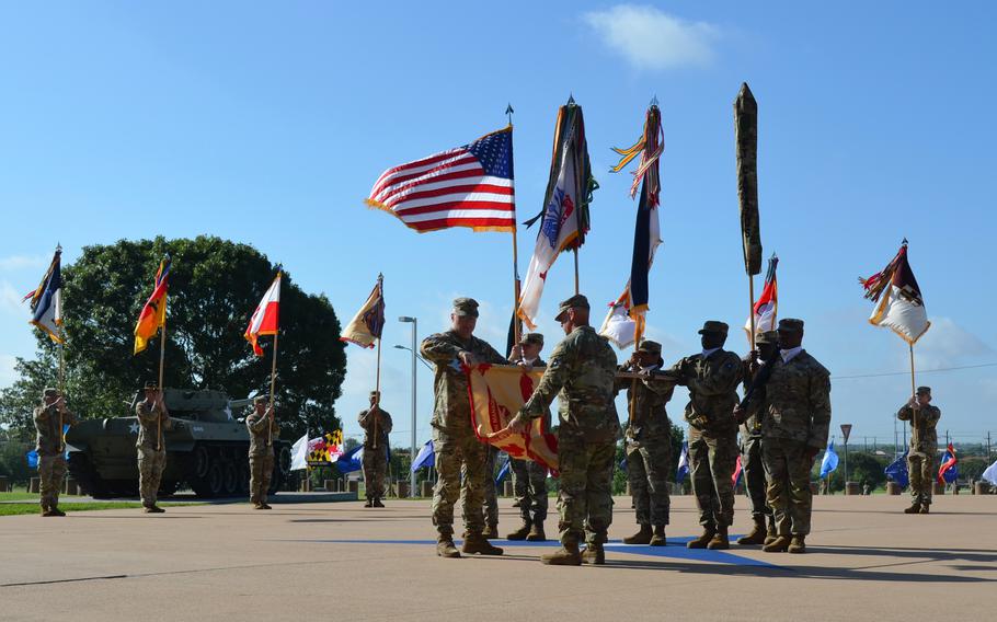Soldiers conduct a ceremony, many of them holding flags.