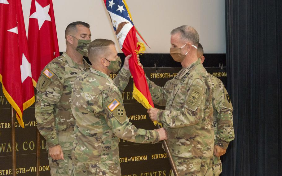 Maj. Gen. David Hill, middle, receives the colors from Lt. Gen. Walter Piatt, right, director of the Army Staff signifying the acceptance of command of the U.S. Army War College, during the change of command ceremony at Carlisle Barracks, on August 31, 2021.