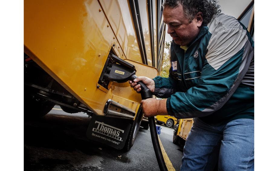 Driver John Walters plugs in his bus for recharging in Bethesda, Md. 