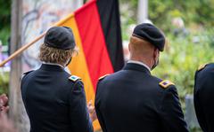 Army leaders attend a Germany Unity Day ceremony by a portion of the Berlin Wall displayed in Ansbach in 2020. German tax authorities are now scrutinizing a family's U.S. military income in Ansbach, a signal that a tax collection operation that the U.S. says misinterprets the NATO Status of Forces Agreement may be spreading to Bavaria.