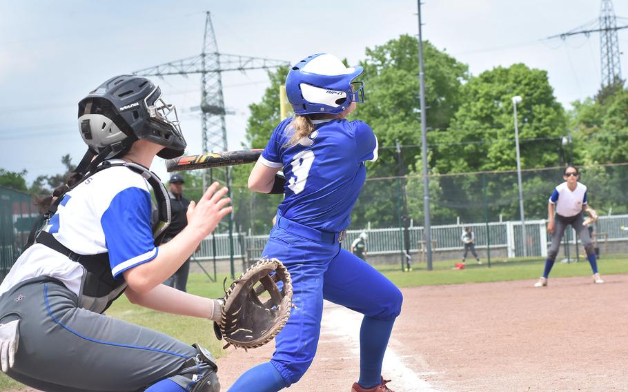 Ramstein's Madison Mihalic and Wiesbaden catcher Maria Pidgeon folllow the ball after Mihalic made contact  in the DODEA-Europe Division I softball championship game Saturday, May 20, 2023, at Kaiserslautern, Germany.