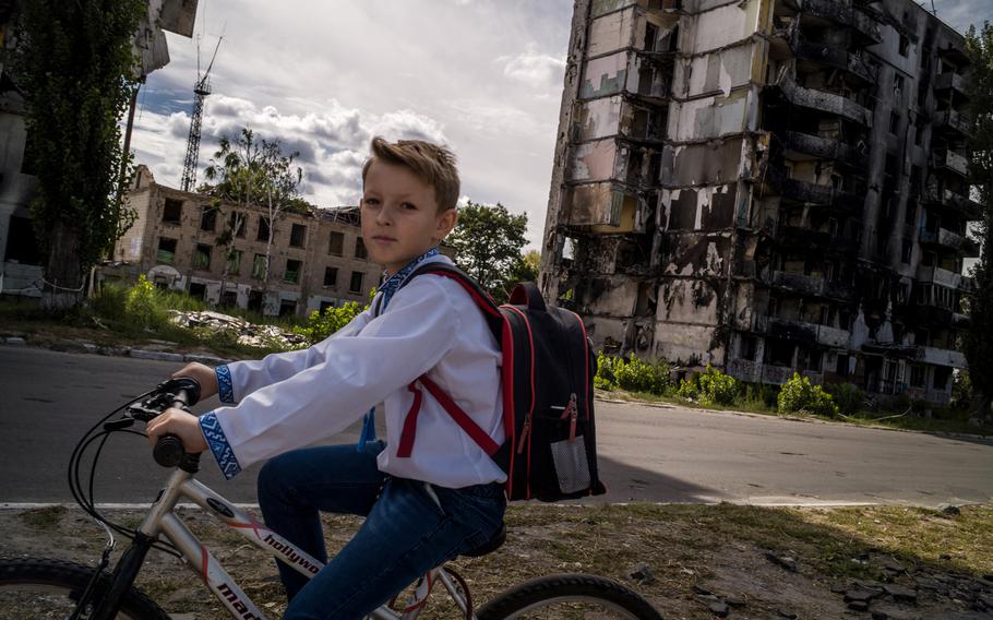 A student rides his bicycle in front of a destroyed building in Borodyanka, Ukraine, on the first day of school. 