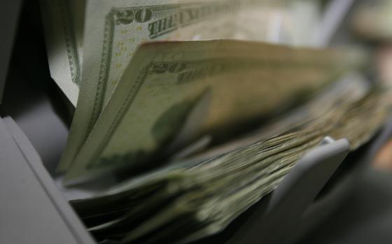Stacks of money are counted by a machine.