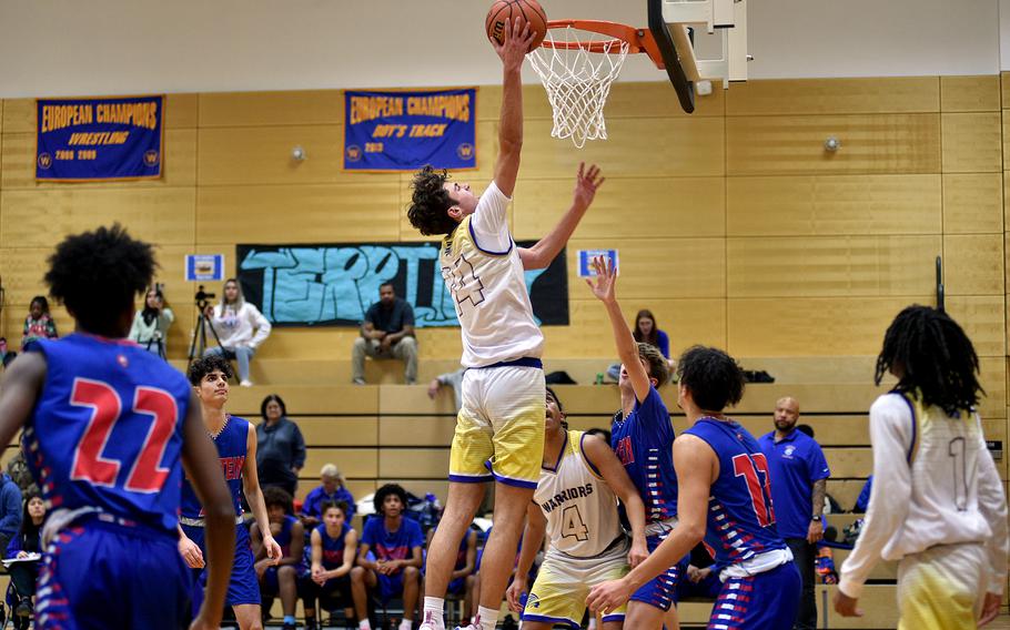 Wiesbaden's Collin Koschnik lays in a bucket during the first quarter of the Warriors' 52-48 loss to Ramstein on Thursday evening at Wiesbaden High School in Wiesbaden, Germany.