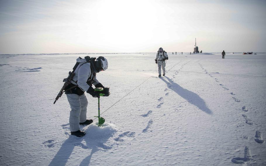 U.S. Navy SEALs and Norwegian naval special operations commandos test ice thickness to establish a landing zone for an MH-47G Chinook helicopter during an integration exercise in the Arctic Ocean on Saturday, March 9, 2024.