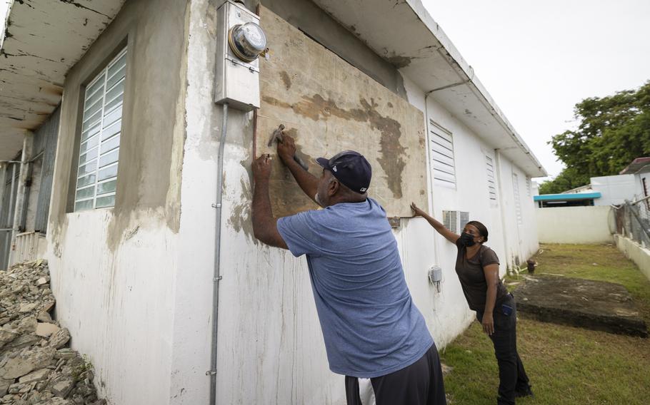 Residents attach protective plywood to a window of their home in preparation for the arrival of Tropical Storm Fiona, in Loiza, Puerto Rico, Saturday, Sept. 17, 2022. Fiona was expected to become a hurricane as it neared Puerto Rico on Saturday, threatening to dump up to 20 inches of rain as people braced for potential landslides, severe flooding and power outages. 