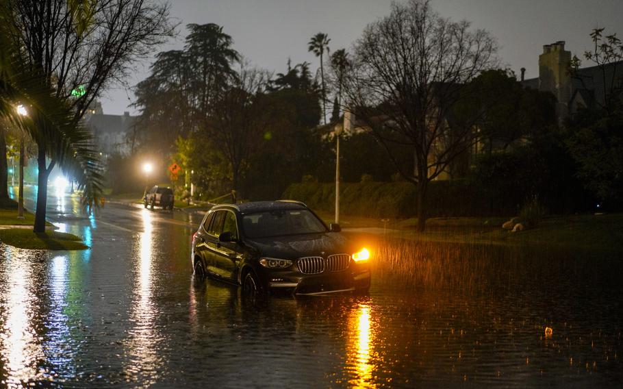 An abandoned car sits in floodwaters during an atmospheric river storm in Los Angeles on Feb. 5, 2024.