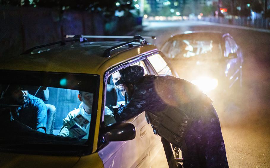 Taliban fighters in their new uniforms station themselves a large traffic junction for a nightly security checkpoint, in Kabul, Afghanistan, on Sept. 5, 2021. 