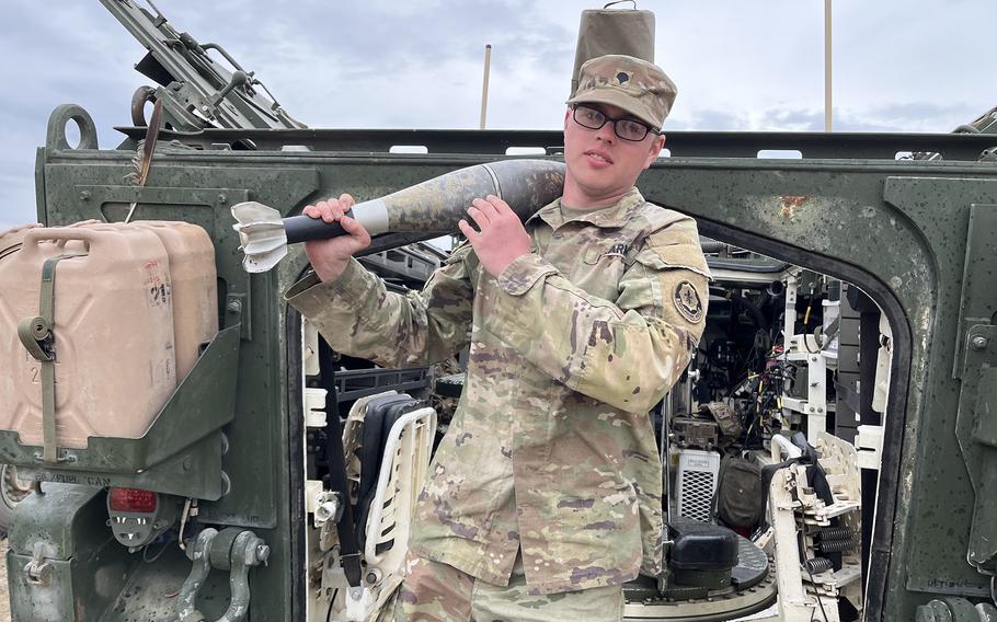 A soldier shows off a mortar round outside his Stryker vehicle.