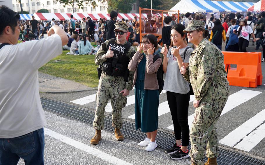 Visitors pose with Navy security during the 44th Friendship Day celebration at Yokosuka Naval Base, Japan, Sunday, Oct. 16, 2022. 