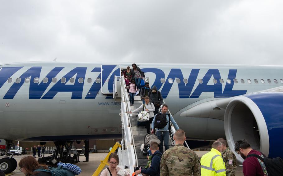 Service members and their families disembark a Patriot Express flight after landing at RAF Mildenhall in England on May 9, 2023. The Patriot Express service, also known as the rotator, will be canceled at Mildenhall on Jan. 1, 2024.