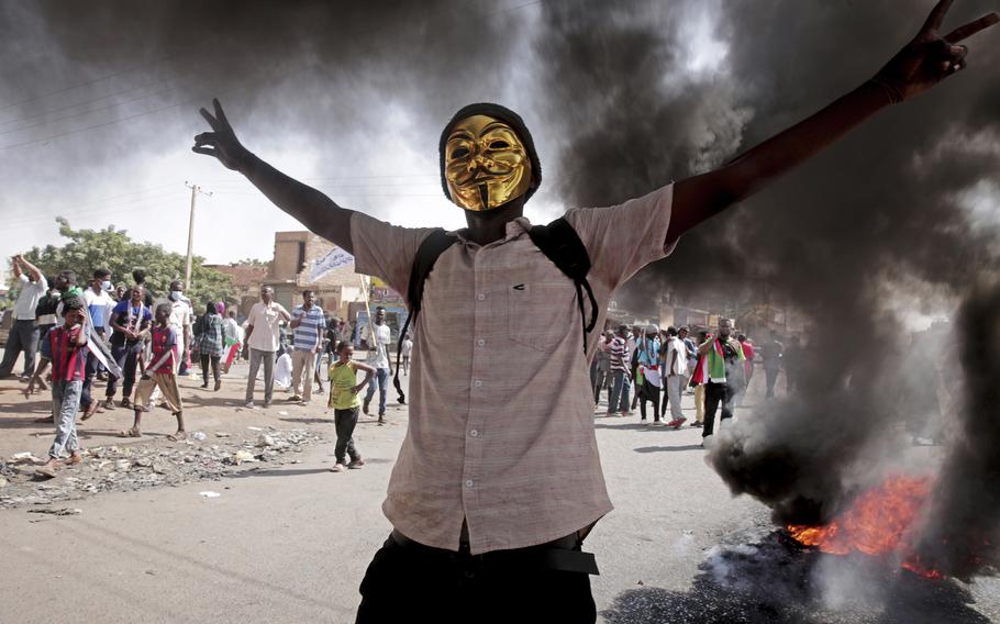 A man flashes the victory sign during a protest to denounce the October 2021 military coup, in Khartoum, Sudan, Sunday, Jan. 9, 2022.