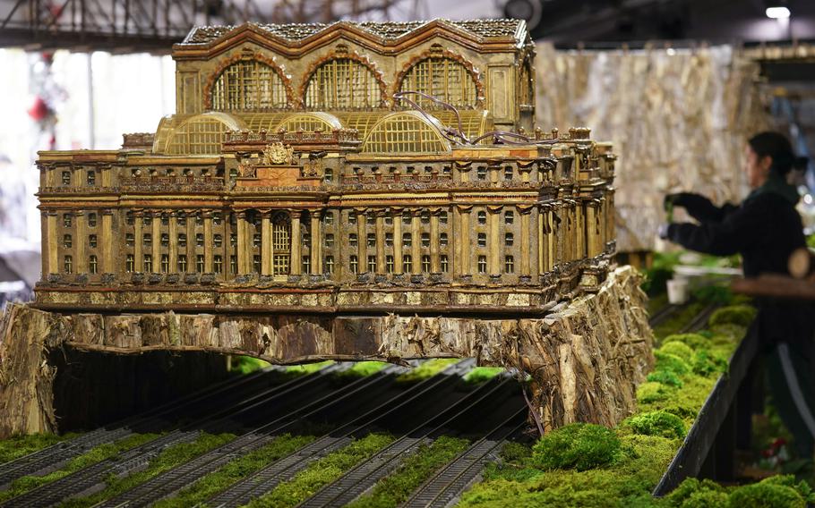 A miniature of the old Penn Station is displayed while people prepare for the annual Holiday Train Show at the New York Botanical Garden in New York, Thursday, Nov. 11, 2021. The show, which opens to the public next weekend, features model trains running through and around New York landmarks, recreated in miniature with natural materials. 