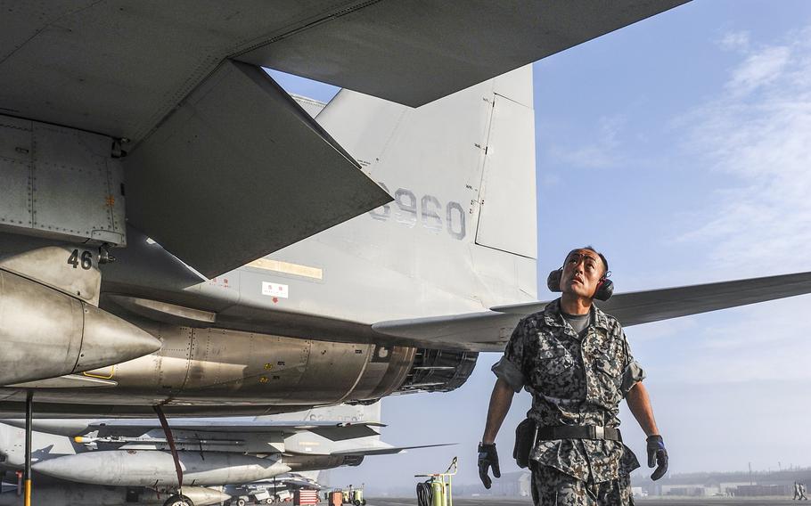 A member of the Japan Air Self-Defense Force inspects an F-15 Eagle during a past Red Flag drill out of Eielson Air Force Base, Alaska