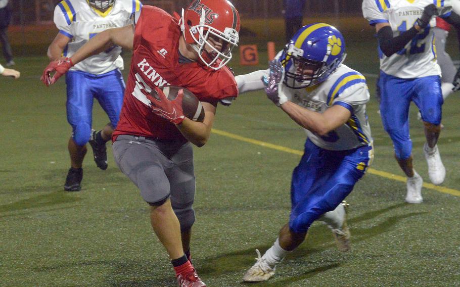 Nile C. Kinnick running back Branden Euceda does his best to elude Yokota defender Owen Taylor.