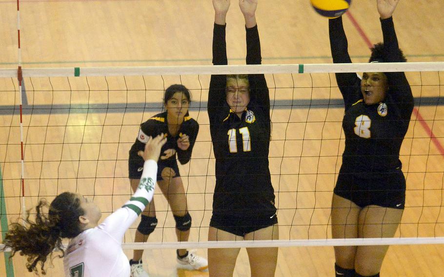 Kubasaki's Sophia Grubbs spikes past the double block of Kadena's Presley Pearce and Kimberly Wright during Thursday's Okinawa girls volleyball match. The Dragons won in three sets.