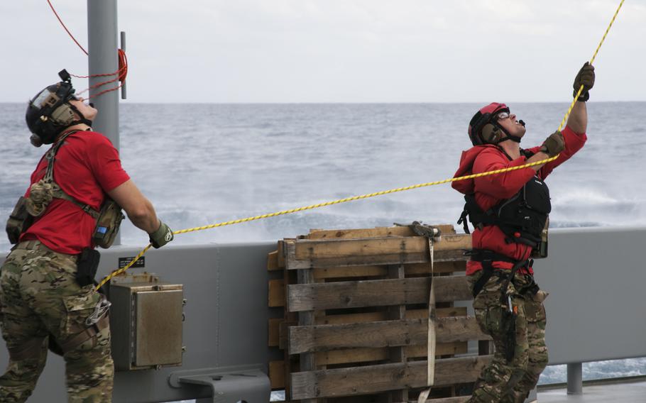 Air Force pararescue specialists of 33rd Rescue Squadron steady a simulated casualty being lifted into a rescue helicopter off Okinawa, Japan, on Nov. 10, 2021. 