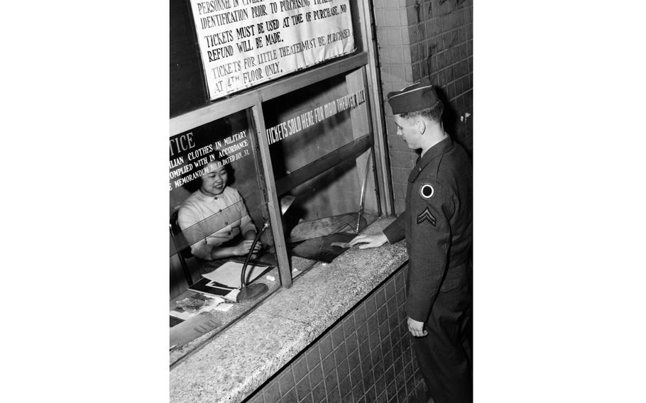 A service member buys a show ticket from a cashier