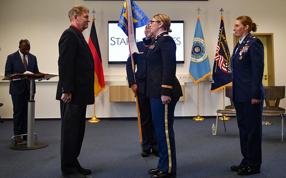 U.S. Army Lt. Col. Katie Fidler salutes Stars and Stripes publisher Max Lederer after taking command of Stars and Stripes Europe and Expeditionary at a ceremony July 12, 2023, at Kleber Kaserne, Kaiserslautern, Germany. At right is the former commander, U.S. Air Force Lt. Col. Marci Hoffman, who will be the next commander of Stars and Stripes Pacific.