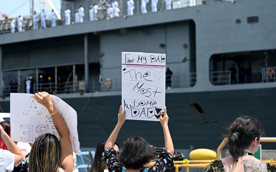 Friends and family of USS Blue Ridge sailors crowd the pier as the amphibious command ship returns.