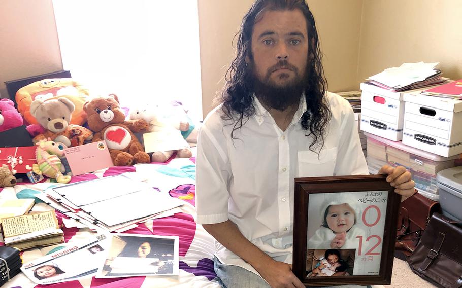 Donny Conway, a former Navy petty officer second class, poses with photos of his daughters, Christina and Chihiro, at his California home on Oct. 17, 2022.