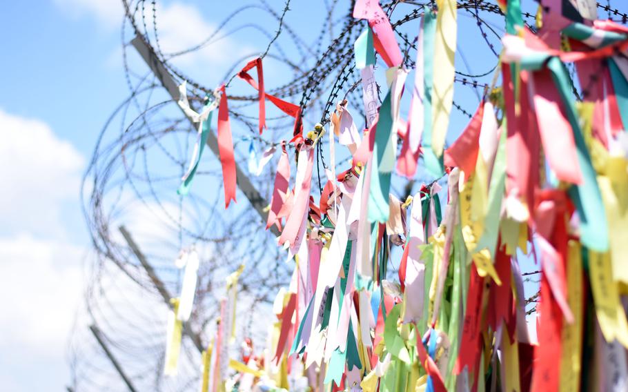 Buddhist prayer ribbons hang from a security fence in Paju, South Korea, near the Demilitarized Zone. 