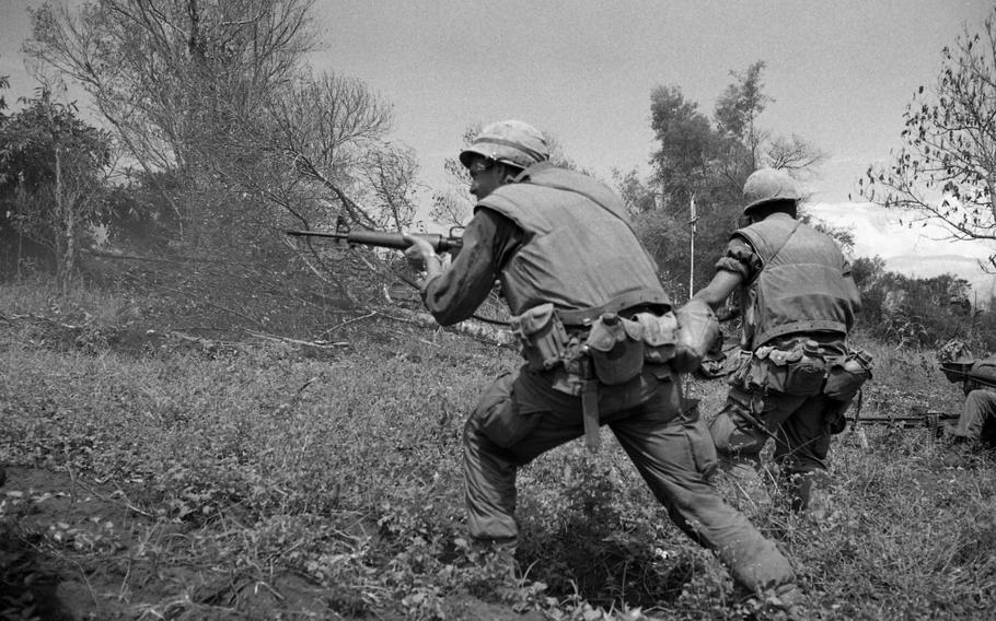 Marines of Alpha Company, 1st Battalion, 9th Marines fire at North Vietnamese Army soldiers. A claymore mine explosion minutes earlier cost the life of the platoon sergeant of Alpha Company.