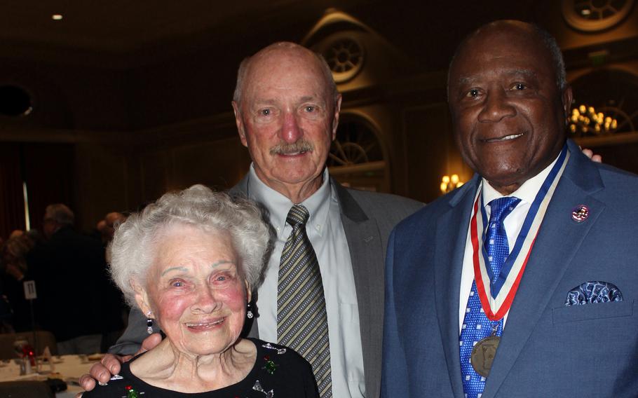 Eleanor Stark holds a photo of her late husband, Luther Bagley, while flanked by their son Nathan Bagley and Georgia state Sen. Ed Harbison at the Georgia Military Veterans Hall of Fame induction ceremony in Columbus, Ga., Nov. 4, 2023.