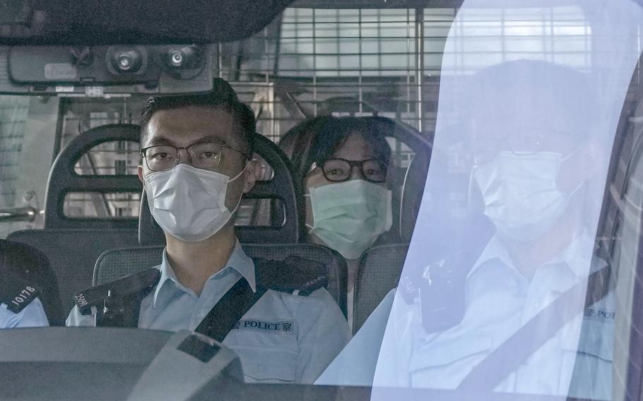 Chow Han Tung, vice chairwoman of the Hong Kong Alliance in Support of Patriotic Democratic Movements of China, center, is escorted by police in a van to a court, in Hong Kong, Friday, Sept. 10, 2021 as she was charged with "inciting subversion of state power" under the national security law.